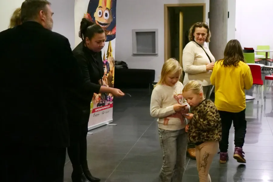 zdjęcie przedstawia widzów oczekujących na wejście na salę teatralną, na foyer w Miejskim Centrum Kultury w Bełchatowie