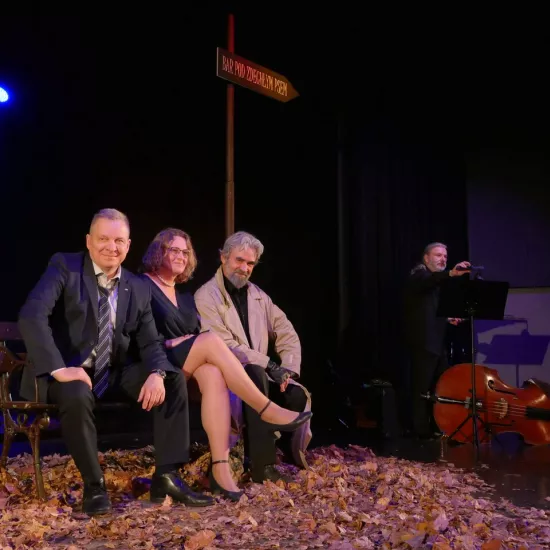 Zdjęcie przedstawia trzy osoby siedzące na ławce na scenie teatralnej. Jedną z nich jest Dariusz Bereski, aktor. Dwie pozostałe Dyrektor MDK w Radomsku oraz pracownica tego ośrodka. 