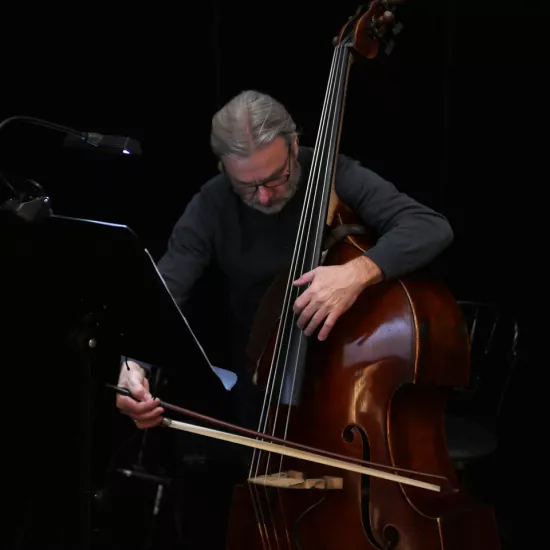 Zdjęcie przedstawia muzyka Tomasza Wilczyńskiego grającego na kontrabasie 
