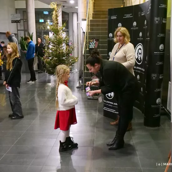 zdjęcie przedstawia widzów oczekujących na wejście na salę teatralną, na foyer w Miejskim Centrum Kultury w Bełchatowie 